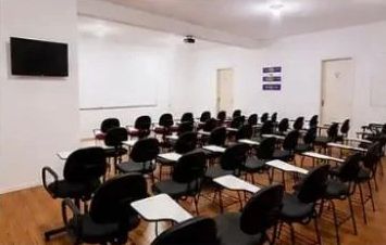 Auditório da APAT com TV de apoio e quadro branco.