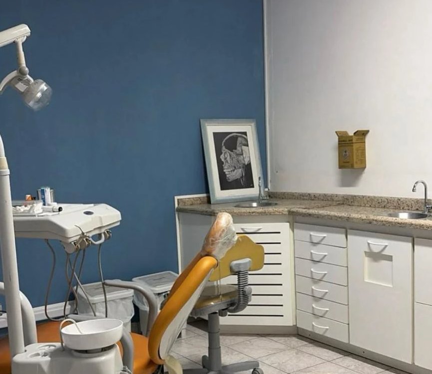 Consultório odontológico D.P Odontológico, com cadeira odontológica, bancada e armários.