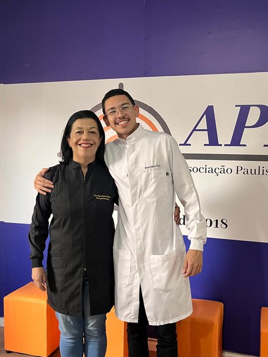 Dentistas do projeto Salvando Sorrisos em frente ao painel da APAT.